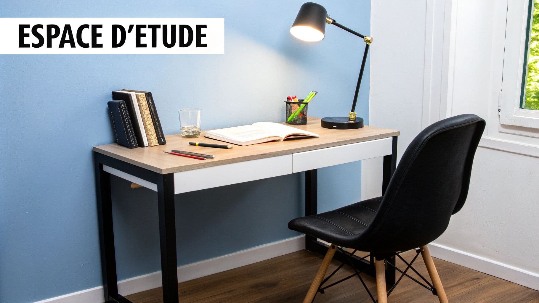 Un bureau en bois clair avec des livres, des fournitures et une lampe allumée, prêt pour l'étude.